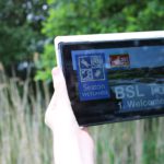 Hands holding an ipad / computer tablet with BSL tour