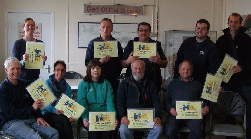 Team of people holding certificates for completing their Disability and Deaf Awareness Training at Geevor Tin Mine