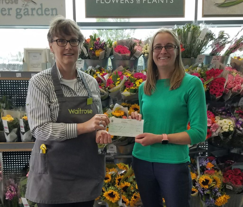 LOD Fundraising officer collecting a cheque from a Waitrose employee following corporate sponsorship in the store