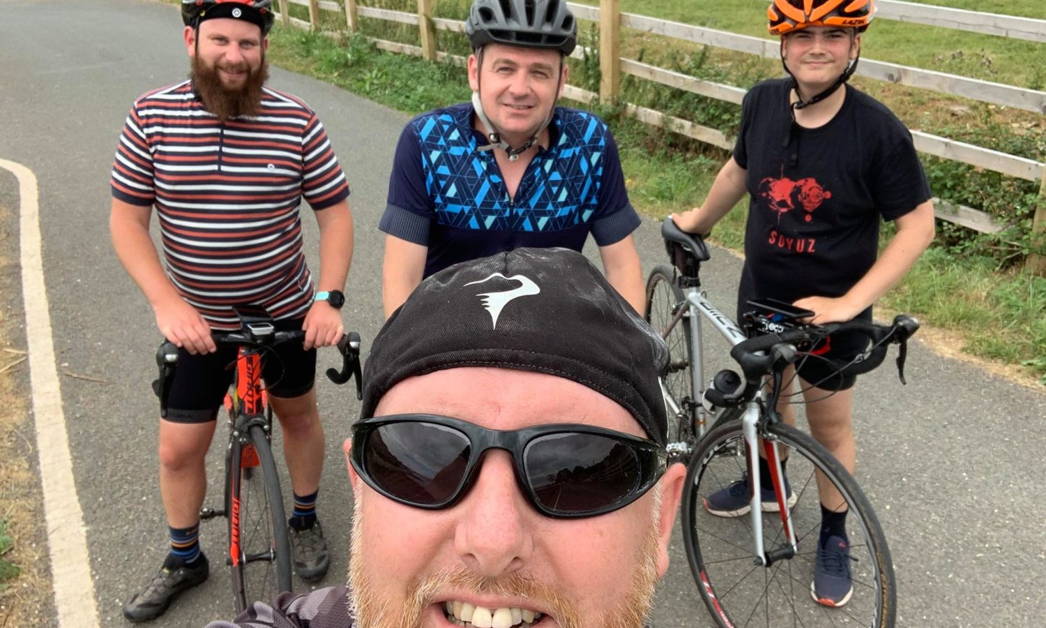 A selfie photo of three men on bicycles