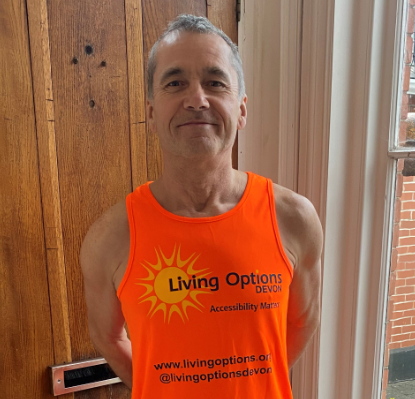 Dave smiling wearing the Living Options Devon orange fundraising t-shirt