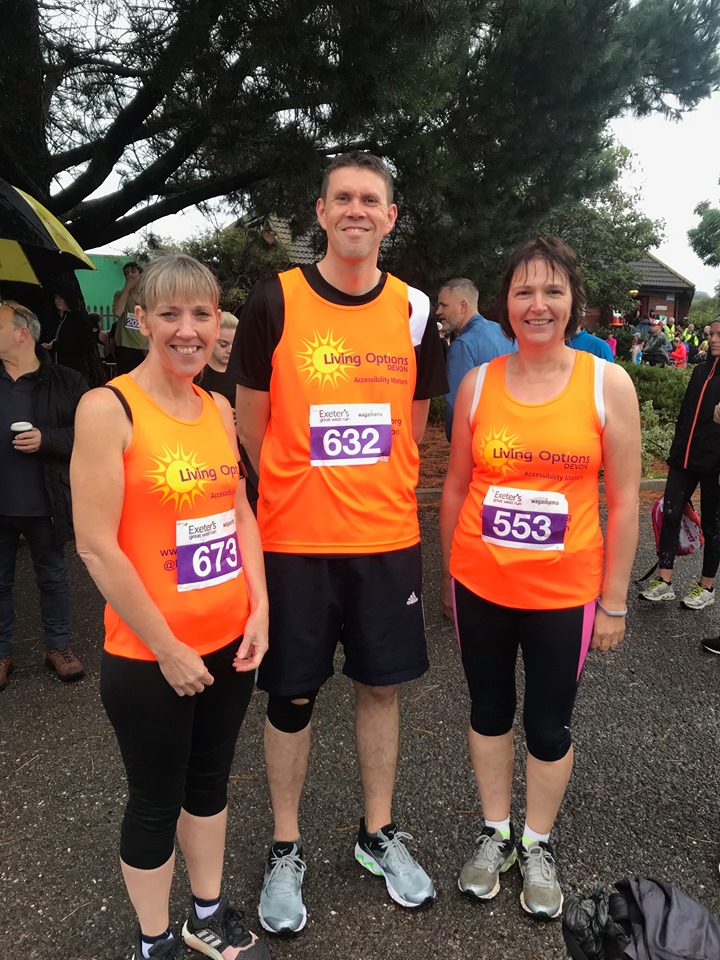 Debbie, Neil and Diane taking part in the Great West Run, they have their running gear on and Living Options Devon orange running vests