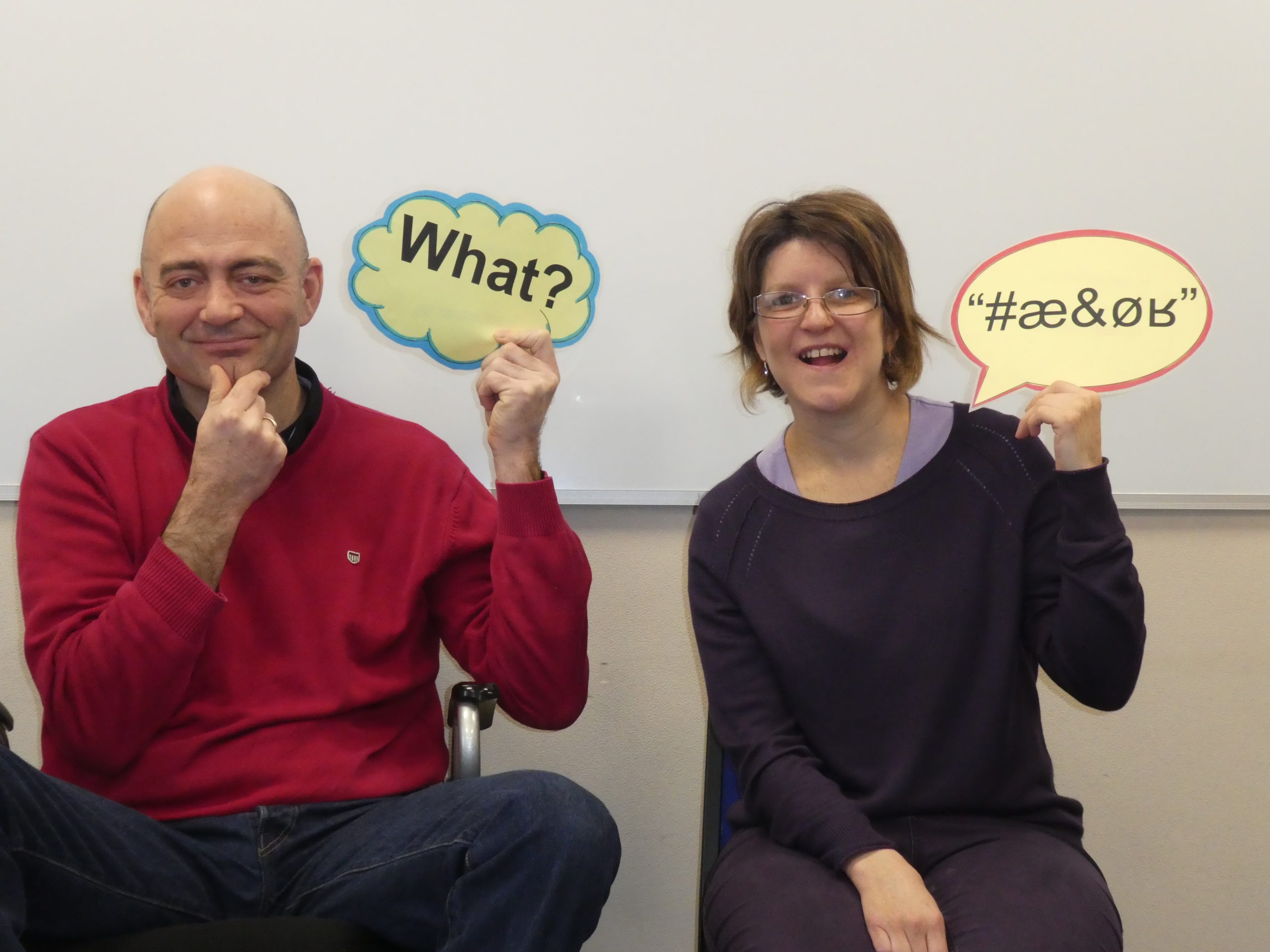 Two people holding speech bubbles looking confused and wanting to ask questions