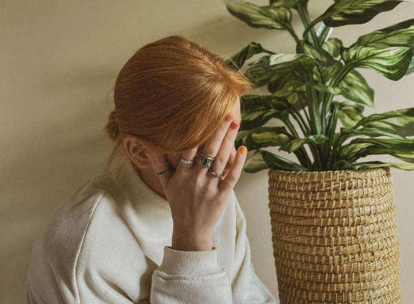 worried woman holding her hand to her head