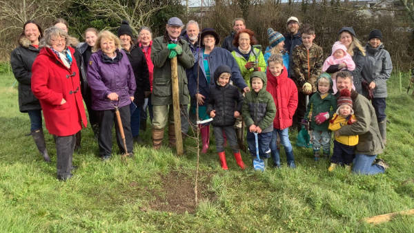 Tree planting group in Devon standing around their planted tree