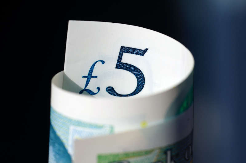 A rolled up five pound note