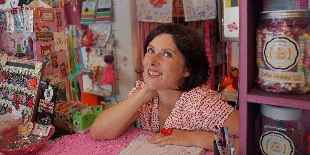 Disabled shop owner behind the shop counter in a colourful shop full of gifts