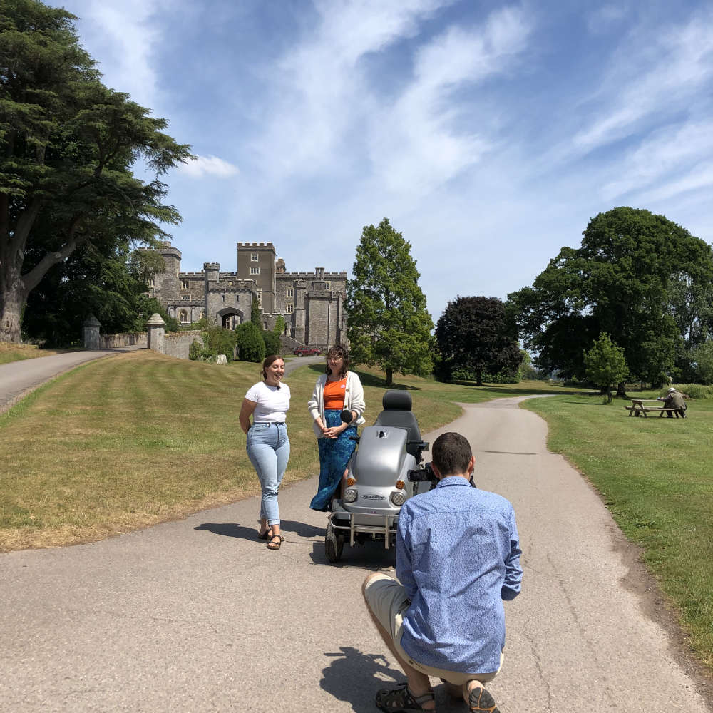 Becki Haddock talking to Naomi Hunt when filming in front of Powderham Castle - sunny with blue sky