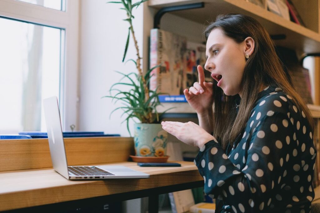 Signing in font of a open laptop on a desk