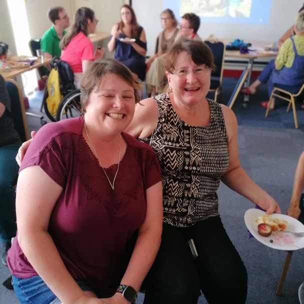 Two ladies smile at the camera 