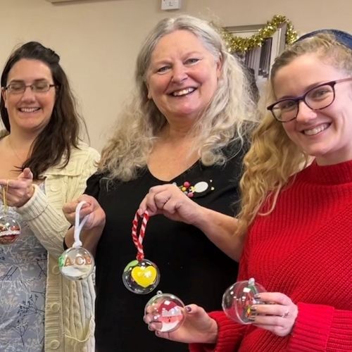 crafters smile and show their christmas baubles